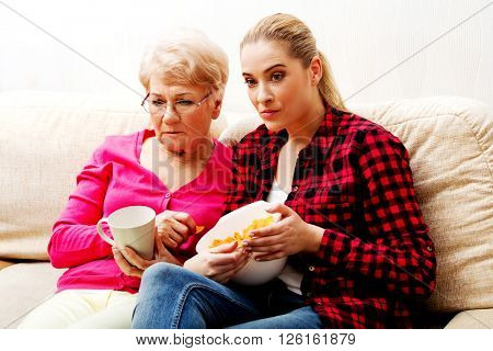 Mother with adult daughter watching sad movie