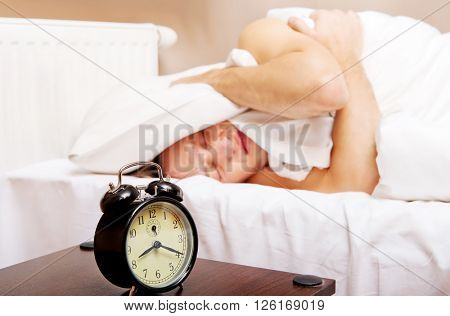 Man trying to sleep, when alarm clock ringing