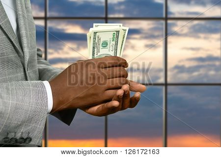 Darkskinned man's hand holding cash. Businessman with dollars at sunrise. Warm up your pocket. Fresh and crispy.
** Note: Visible grain at 100%, best at smaller sizes