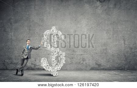 Young confident businessman leaning on big dollar sign