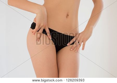 A young girl in her underwear on a white background