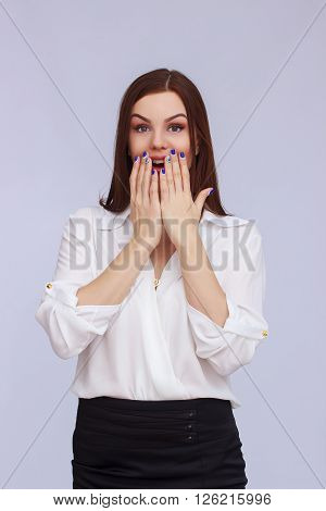 Portrait of surprised business woman on grey background