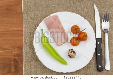 The diet for weight loss. Healthy food. Breakfast for athletes. Ham, tomatoes, pepper and quail eggs.