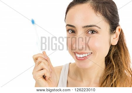 Caucasian friendly woman showing her toothbrush. Isolated on white background.