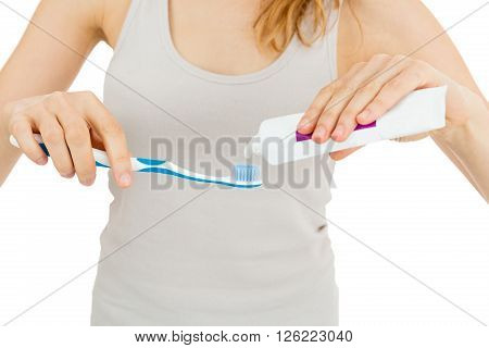 Woman applying toothpaste to toothbrush. Isolated on white background.