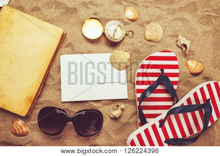 Beach ready summer holiday vacation accessories on sandy beach - vacation mood and summer lifestyle objects in flat lay top view arrangement.