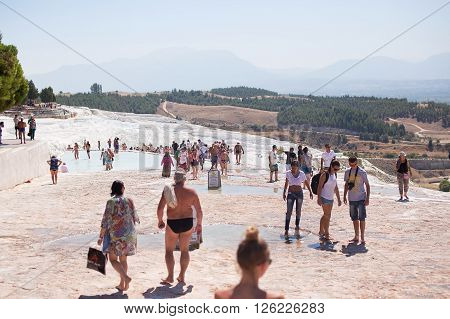 PAMUKKALE TURKEY - September 13 2015: Tourists regard the travertines with pools and terraces at Pamukkale. Pamukkale is included in the UNESCO World Heritage List.