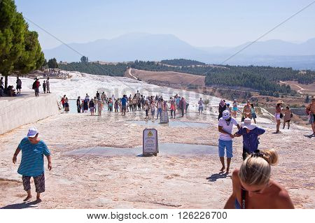 PAMUKKALE TURKEY - September 13 2015: Tourists regard the travertines with pools and terraces at Pamukkale. Pamukkale is included in the UNESCO World Heritage List.