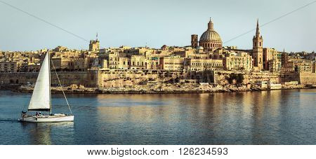 panoramic view of Valetta over sunset and with a sail boat. Malt
