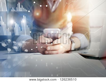 Business concept picture.Account manager working new startup project modern office.Holding contemporary smartphone hands. Worldwide connection technology, stock exchanges graphics interface.