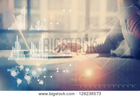 Business concept image.Businessman working investment project modern office.Touching pad contemporary laptop. Worldwide connection technology, stock exchanges graphics interface.