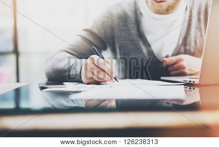 Investment manager work process.Photo man working paper documents. Private banker using pen for signs contracts. New business project startup. Flares and film effects