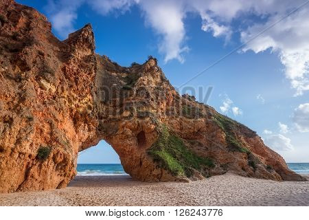 Rock cliff arches on Prainha beach and turquoise sea water on coast of Portugal in Algarve region