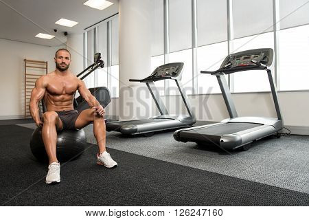 Young Man Resting In Healthy Club After Exercising