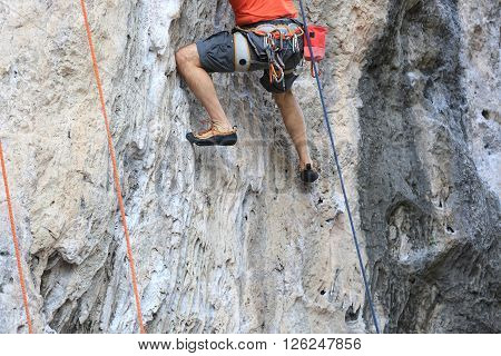 closeup of male rock climber legs climing