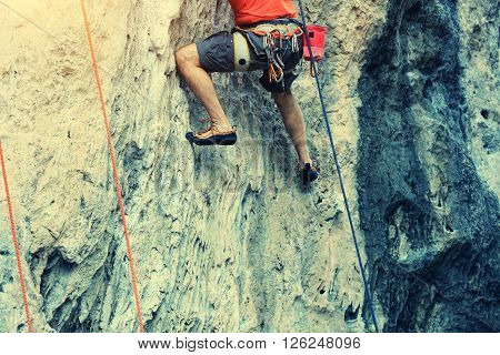 closeup of male rock climber legs climing