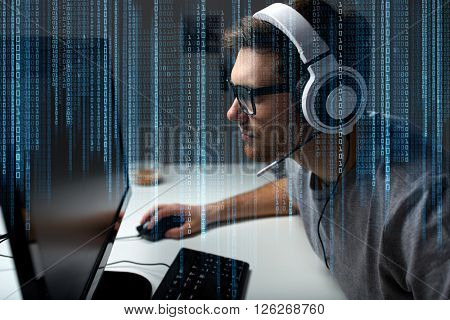 technology, gaming, entertainment, let's play and people concept - young man in headset and glasses with pc computer playing game at home and streaming playthrough or walkthrough video
