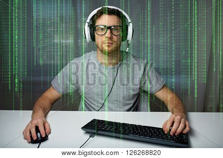technology, gaming, entertainment, let's play and people concept - young man in headset and eyeglasses with pc computer playing game at home and streaming playthrough or walkthrough video