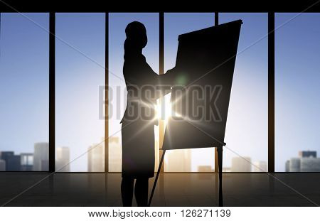 business, strategy, planning and people concept - silhouette of woman with flipboard over office window background