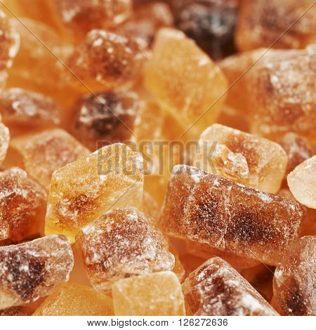 Surface coated with multiple large brown rock sugar crystals as a background composition
