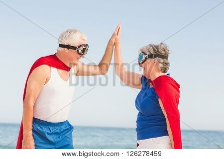 Senior couple wearing superman costume on a sunny day