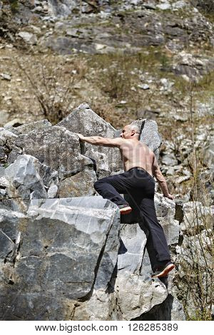 Man free climbing on huge boulders on a mountain