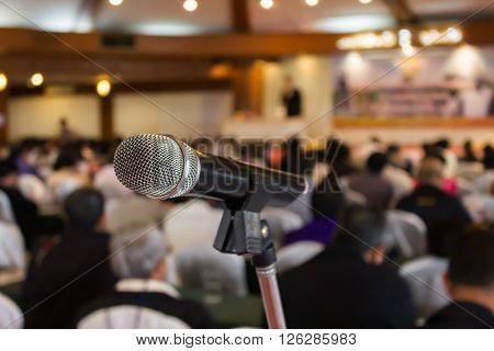 Microphone set up on blurred people in seminar event hall
