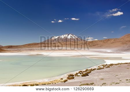 South America - Bolivia. The surreal landscape is nearly treeless punctuated by gentle hills and volcanoes near Chilean border. The picture present lagoon Kota