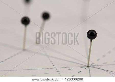 Black Pins In Paper Linked By Lines