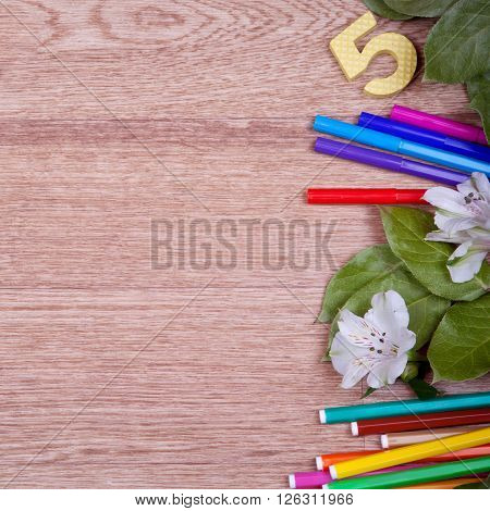 Colored pencils, pencil sharpener, ruler on a wooden board