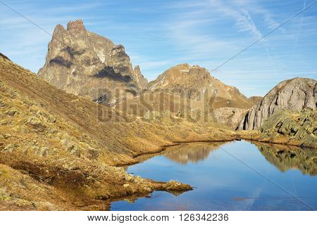 Midi Dossau Peak reflected in a lake. Ossau Valley, Pyrenees National Park, Pyrenees, France.