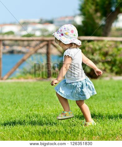 Little baby girl running outdors, summer time