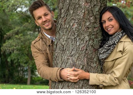 enamoured couple behind a tree