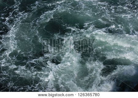 Foamy ocean wake from the side of a boat.