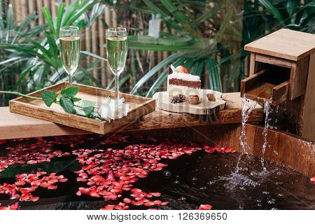 Onsen series : Wooden bathtub filled with roses petal