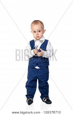 Portrait of a little boy in a blue business suit with a spanner in his hand isolated on white background