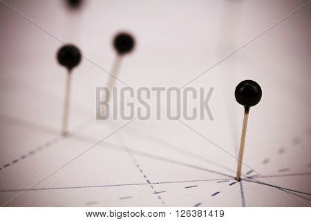 Black Pins In Paper Linked By Lines