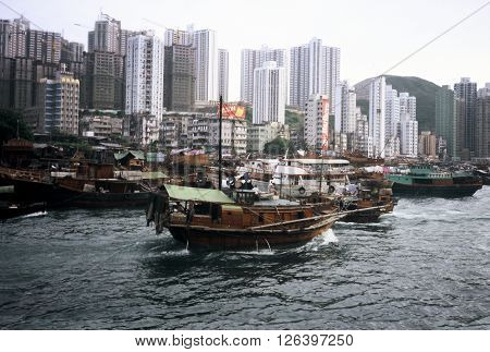 ABERDEEN / HONG KONG - CIRCA 1987: A houseboat enters the harbor at the Aberdeen Floating Village in Hong Kong.