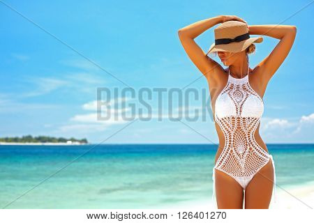 Beautiful woman wearing crochet bikini posing over the sea view, beach lifestyle