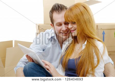 a couple arranging new apartment with digital tablet