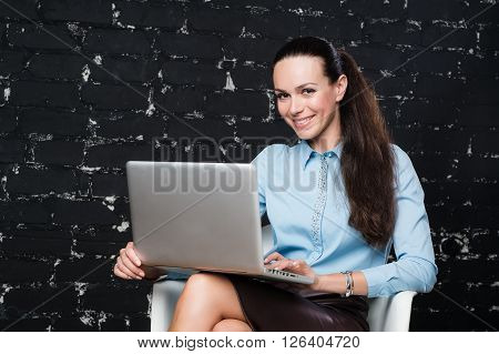 Russian business lady looking straight to the camera on the black brick background for use e.g. in collages, presentation