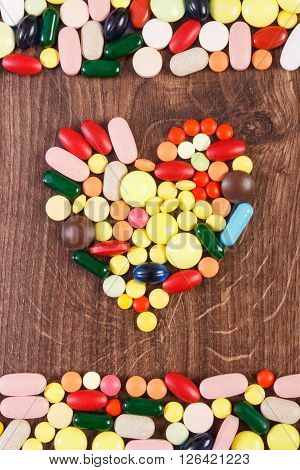 Heart shaped colorful medical pills capsules or supplements for therapy concept of treatment