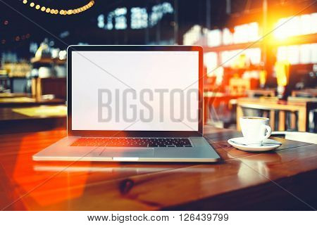 Portable laptop computer with copy space screen for your text message or promotional content open net-book lying on a table in cafe bar interior distance work via internet during coffee break
