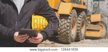 Construction engineer making notes on a tablet.
