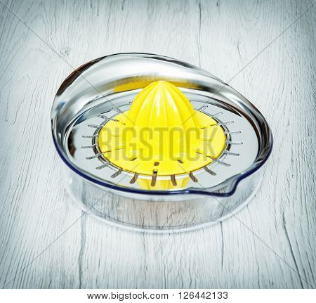 Yellow citrus juicer on the wooden background. Kitchen equipment.