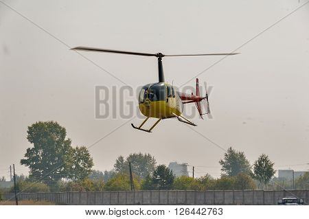 Tyumen, Russia - August 11, 2012: On a visit at UTair airshow in heliport Plehanovo. Pilot of Robinson R44 Raven shows flying opportunities
