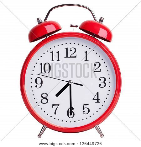 Red round alarm clock shows half past seven