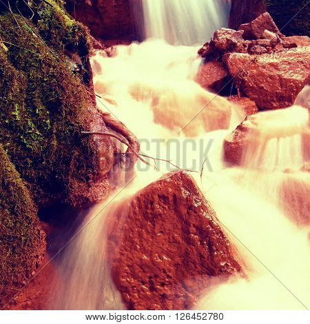 Cascades In Rapid Stream Of Mineral Water. Red Ferric Sediments On Big Boulders
