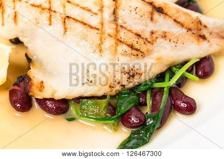 Delicious baked dorado fillet with chard and beans. Macro. Phoro can be used as a whole background.