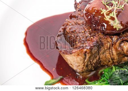Delicious grilled fillet mignon steak with chard covered with red wine sauce. Macro. Selective focus on the top of steak. Photo can be used as a whole background.